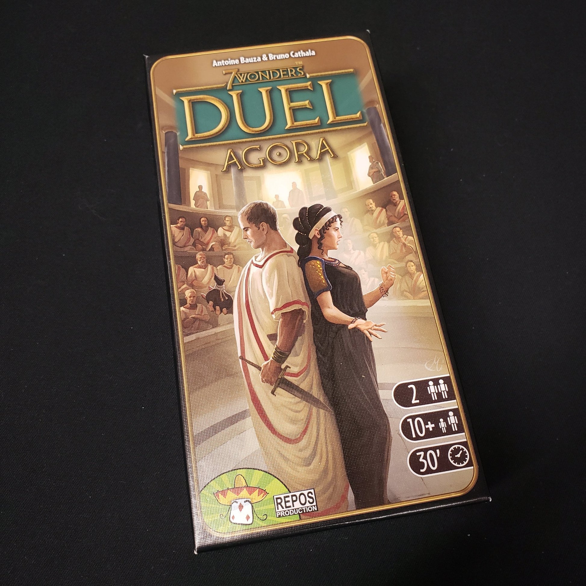 Image shows the front cover of the box of the Agora expansion for the board game 7 Wonders Duel