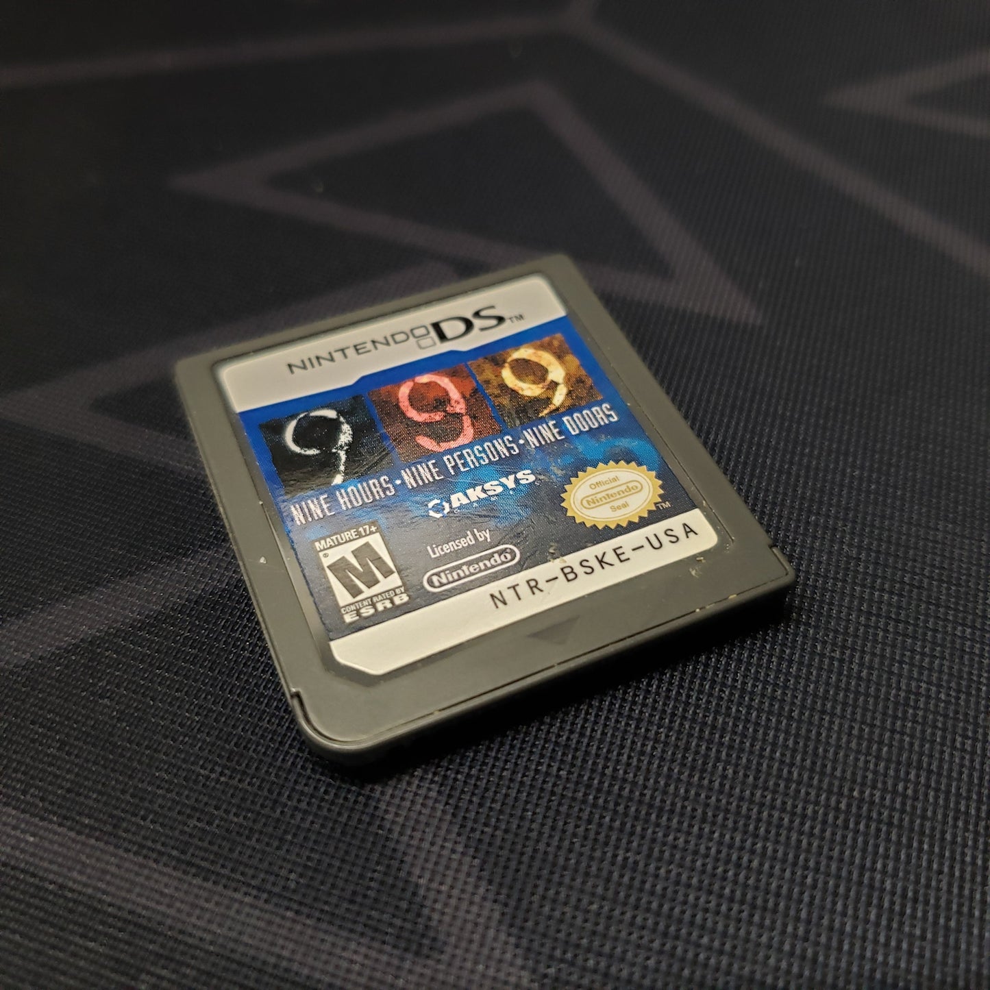 Image shows the front of the cartridge for the video game 999: Nine Hours, Nine Persons, Nine Doors for Nintendo DS