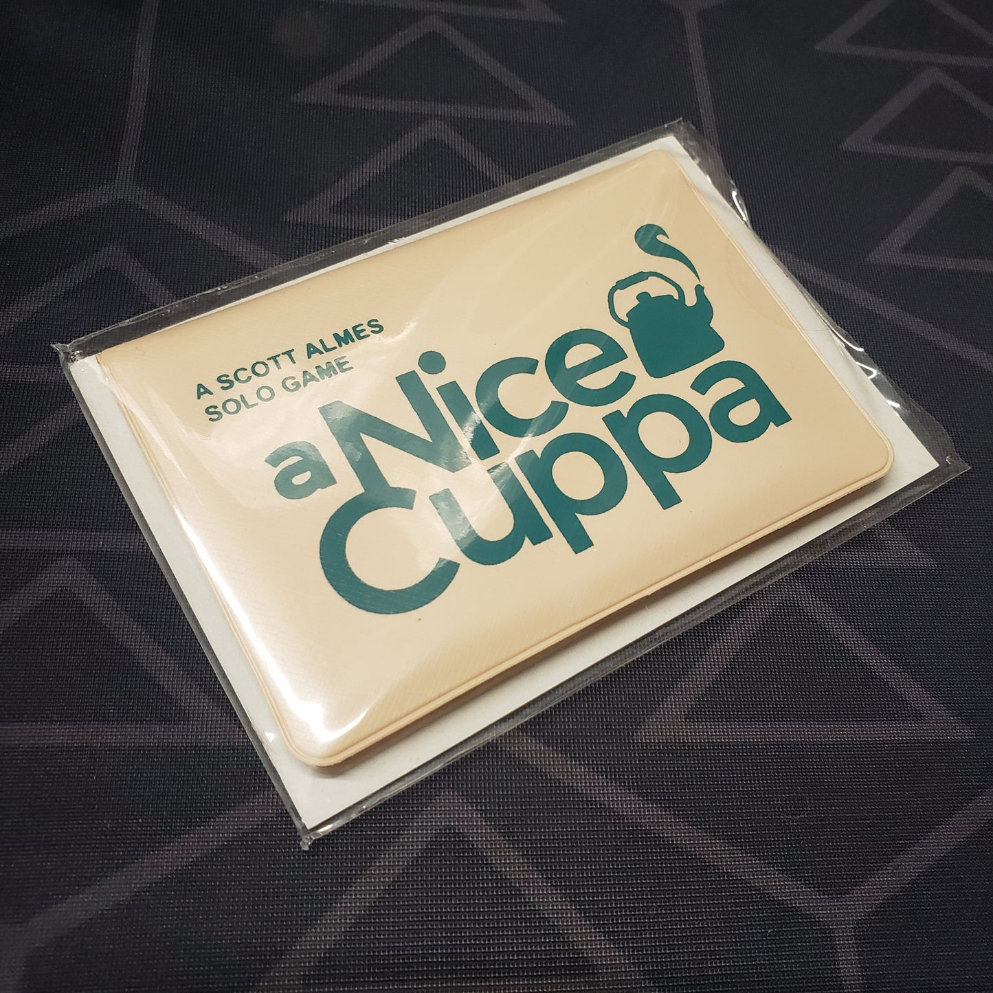 Image shows the front of the card wallet for the card game A Nice Cuppa
