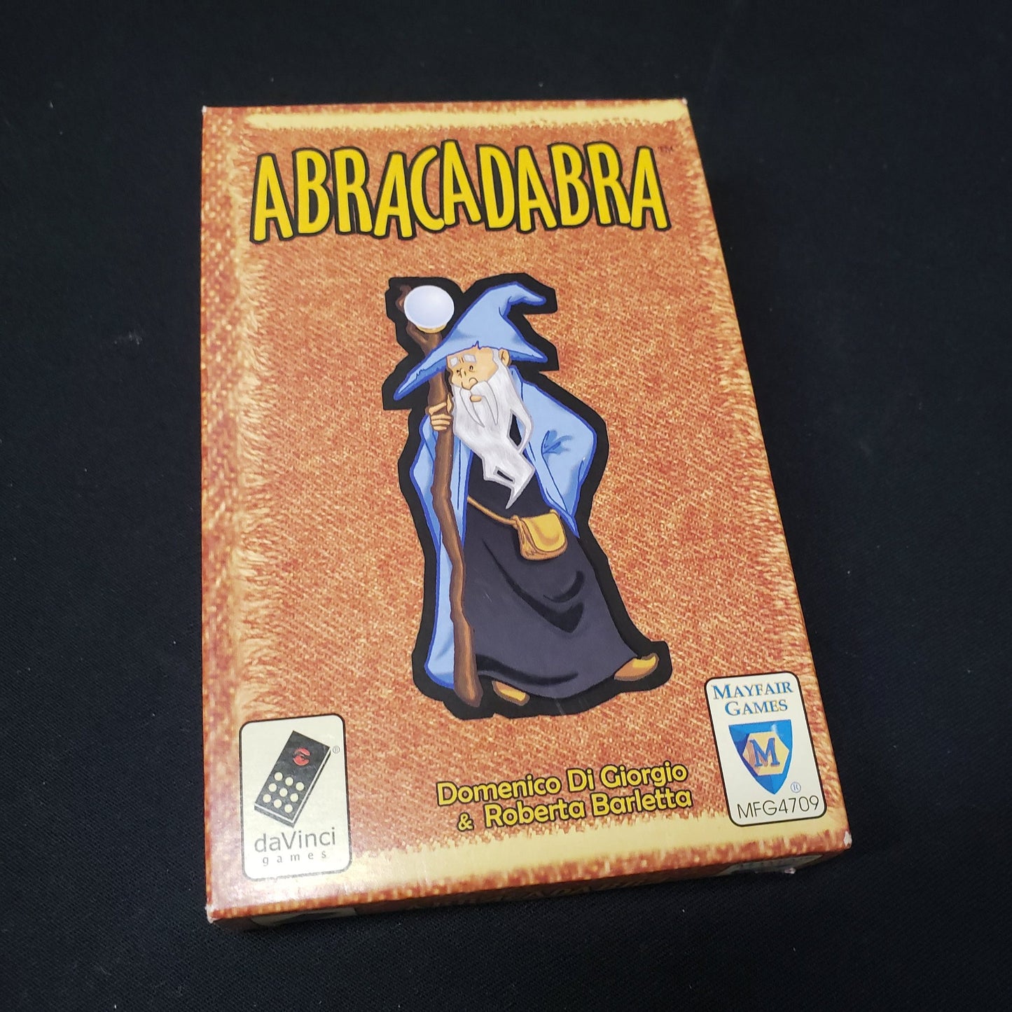 Image shows the front cover of the box of the Abracadabra card game