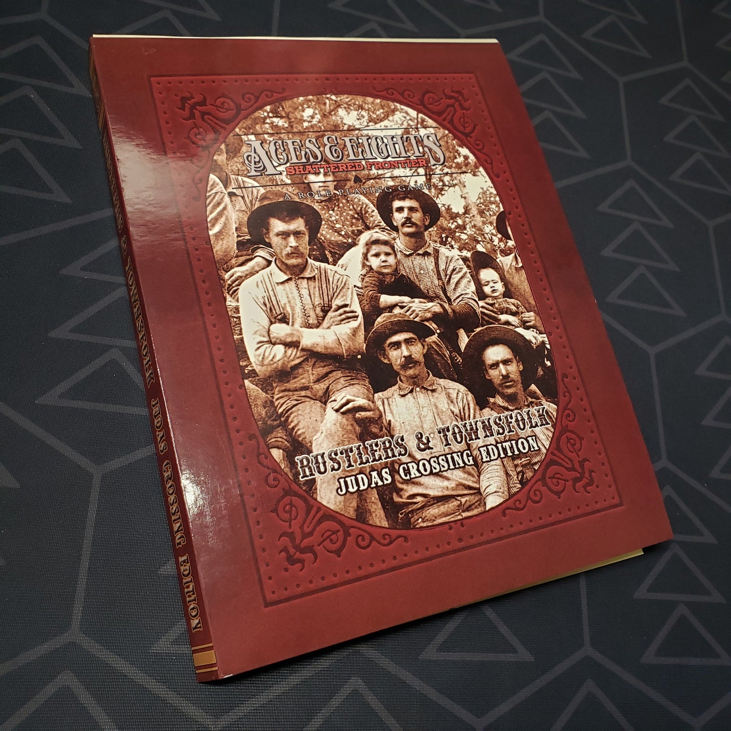 Image shows the front cover of the Rustlers & Townsfolk: Judas Crossing Edition book for the roleplaying game Aces & Eights: Shattered Frontier