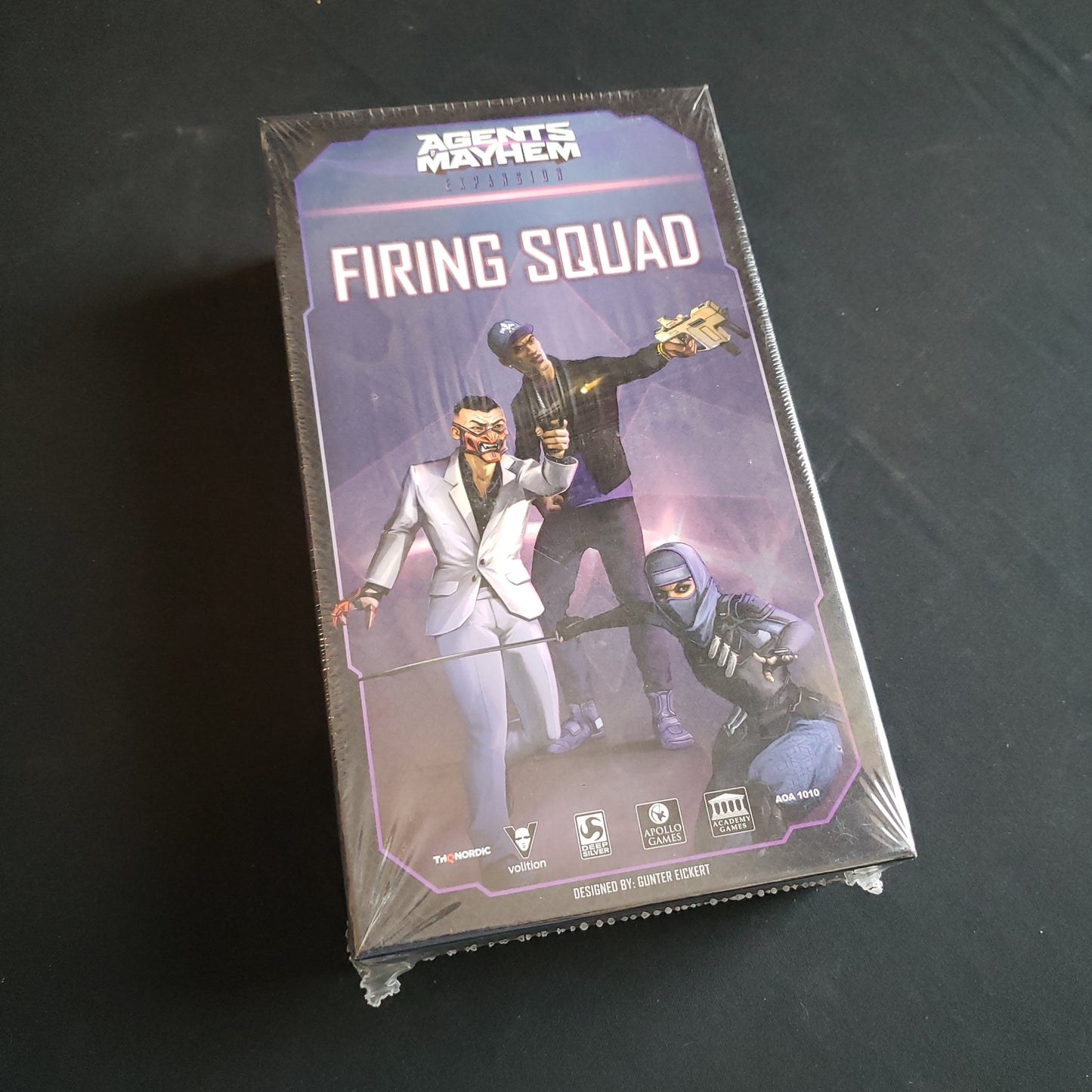 Image shows the front cover of the box of the Firing Squad expansion for the board game Agents of Mayhem