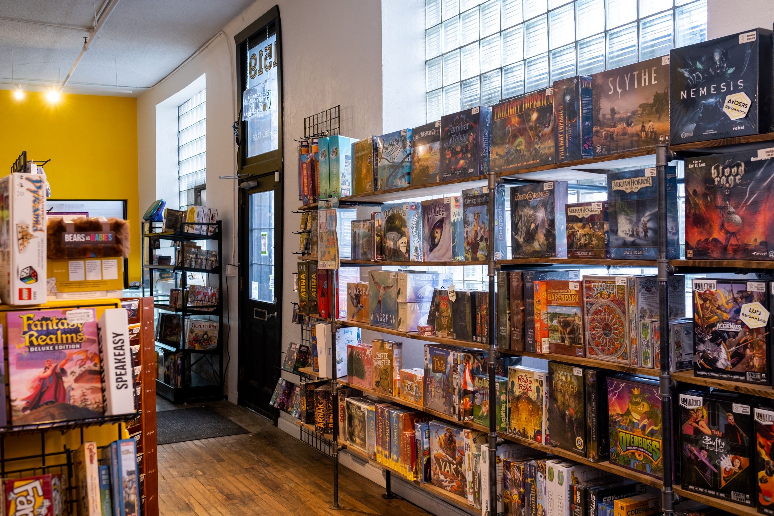 Image shows the interior of All Systems Go's storefront in northeast Minneapolis, featuring several shelves of new board games.