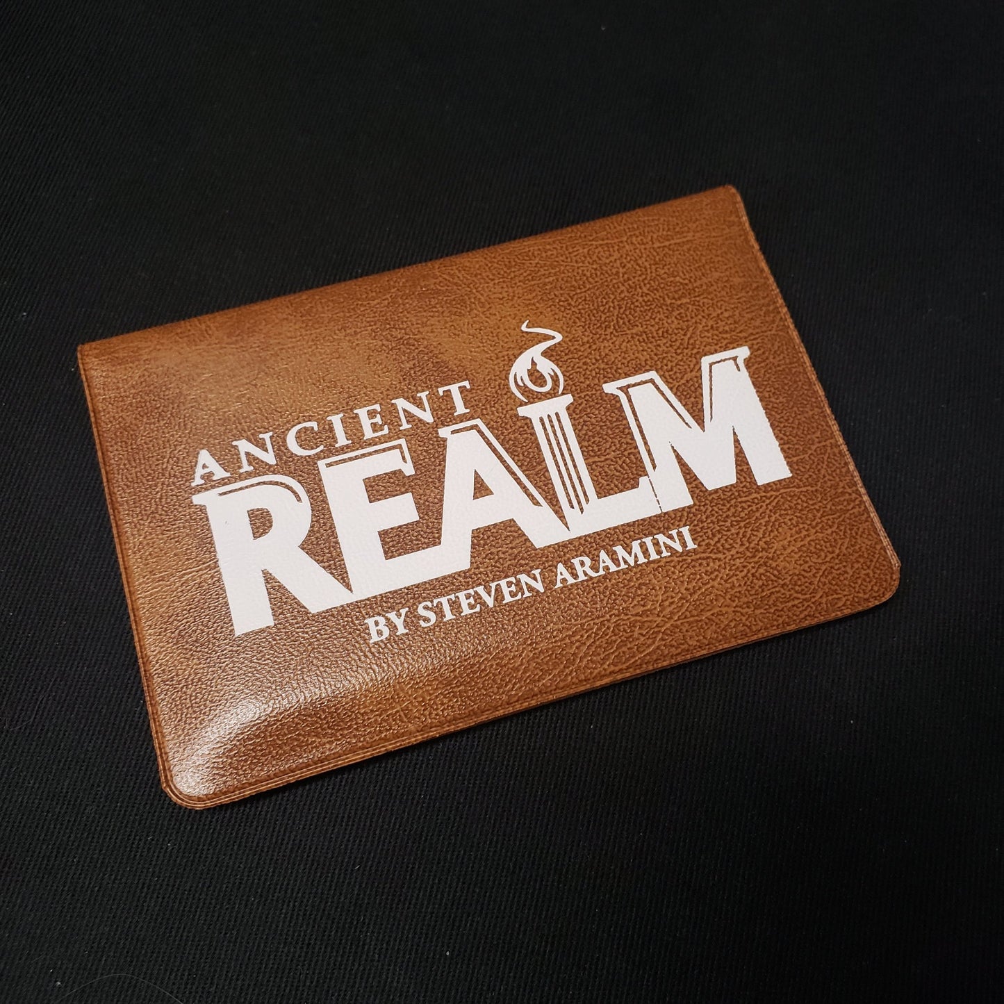 Image shows the front cover of the card wallet packaging of the Ancient Realm card game