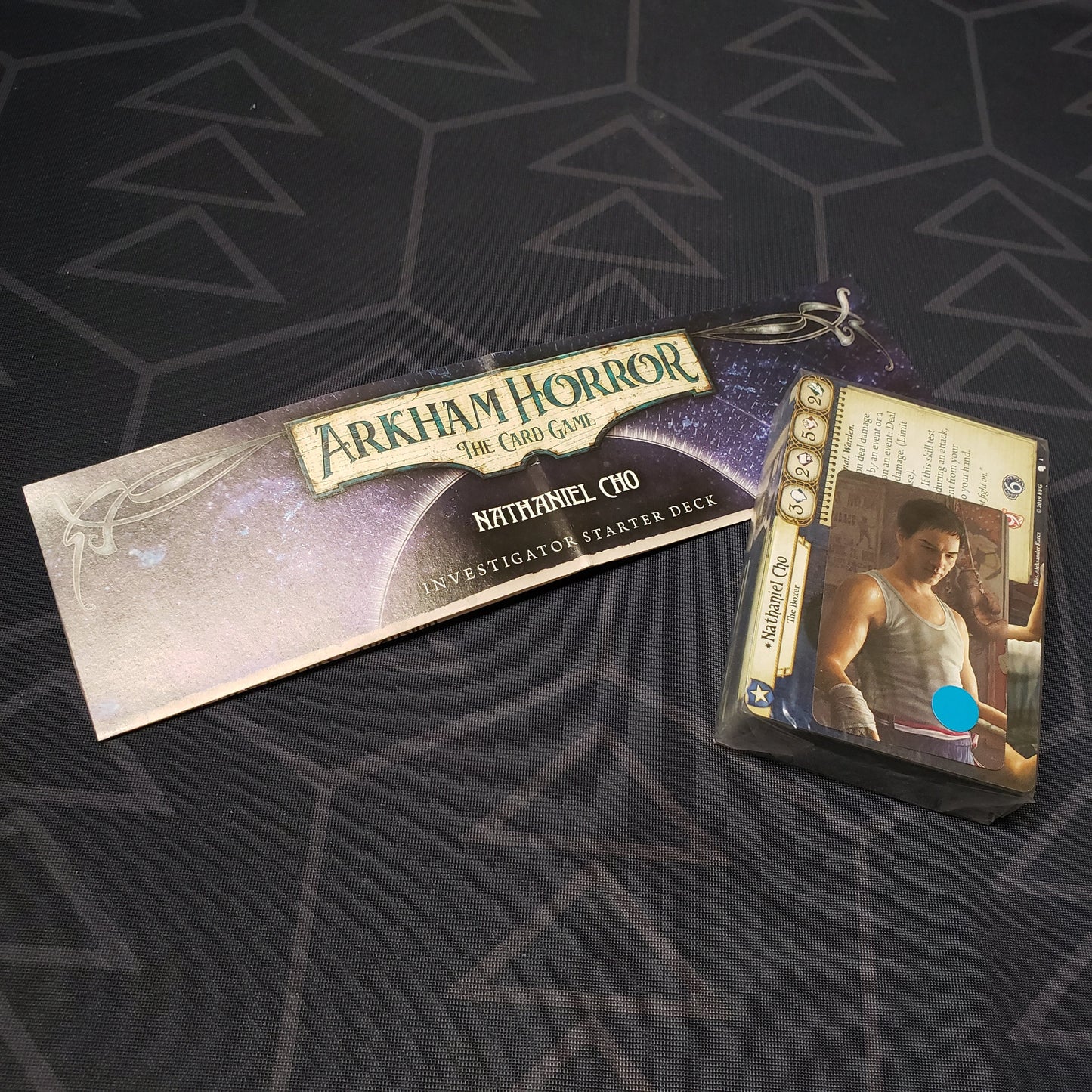 Image shows the shrinkwrapped cards & instructions for the Nathaniel Cho Investigator Starter Deck from the Arkham Horror Card Game