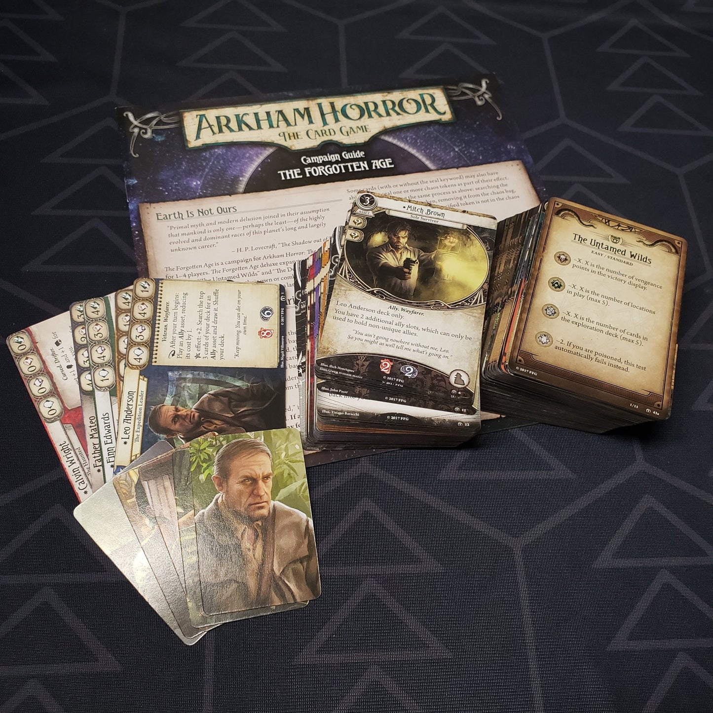 Image shows the fanned-out cards & instructions for the Forgotten Age expansion for Arkham Horror: The Card Game