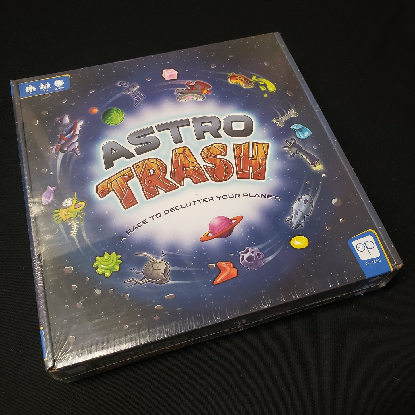 Image shows the front cover of the box of the Astro Trash board game