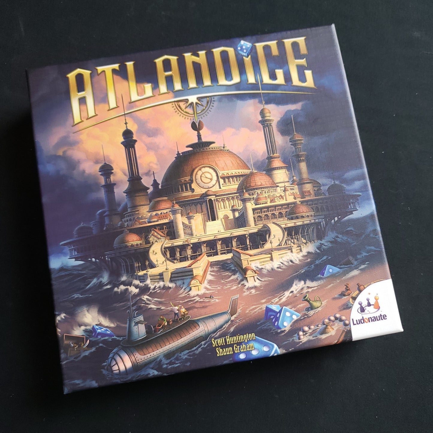 Image shows the front cover of the box of the Atlandice board game