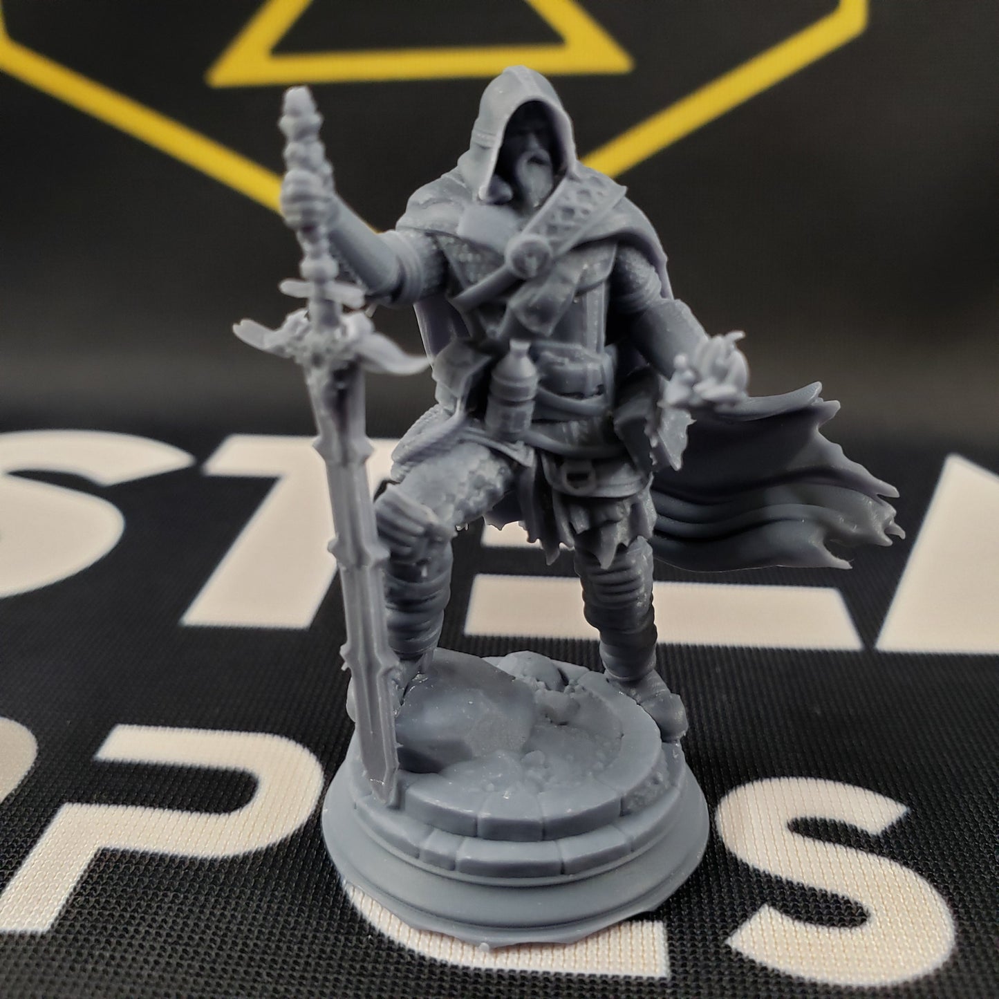 Image shows a 3D printed undead ranger gaming miniature, holding a large sword in one hand and conjuring a spell with the other