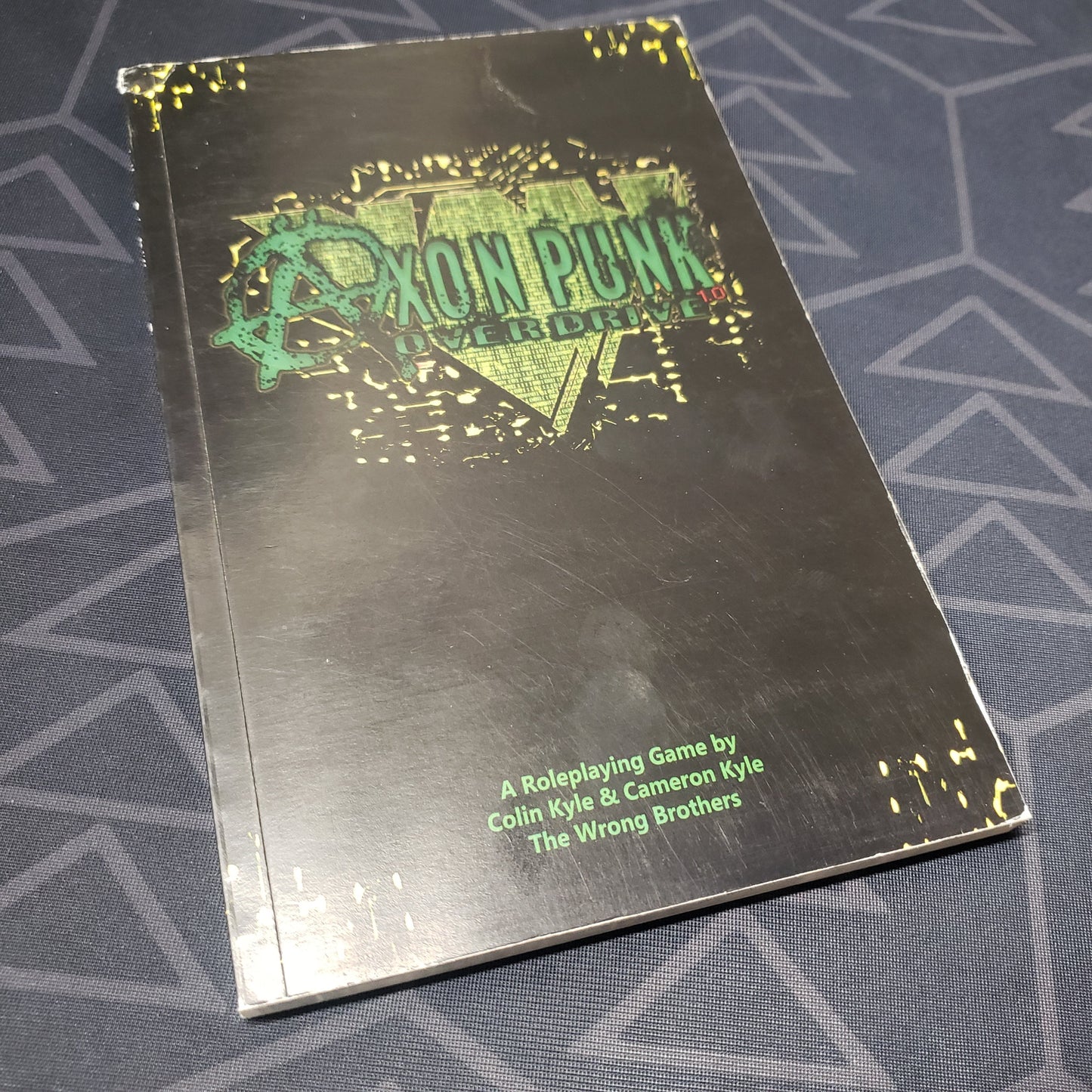 Image shows the front cover of the core rulebook for the roleplaying game Axon Punk: Overdrive