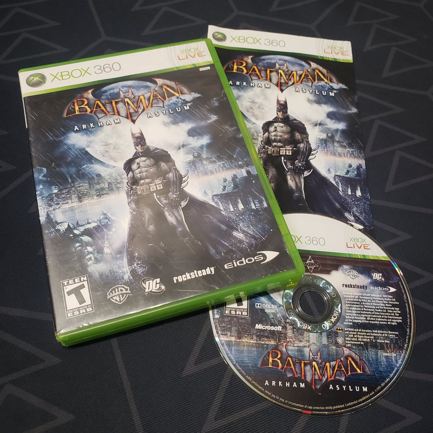 Image shows the case, manual and disc for the video game Batman: Arkham Asylum for Xbox 360