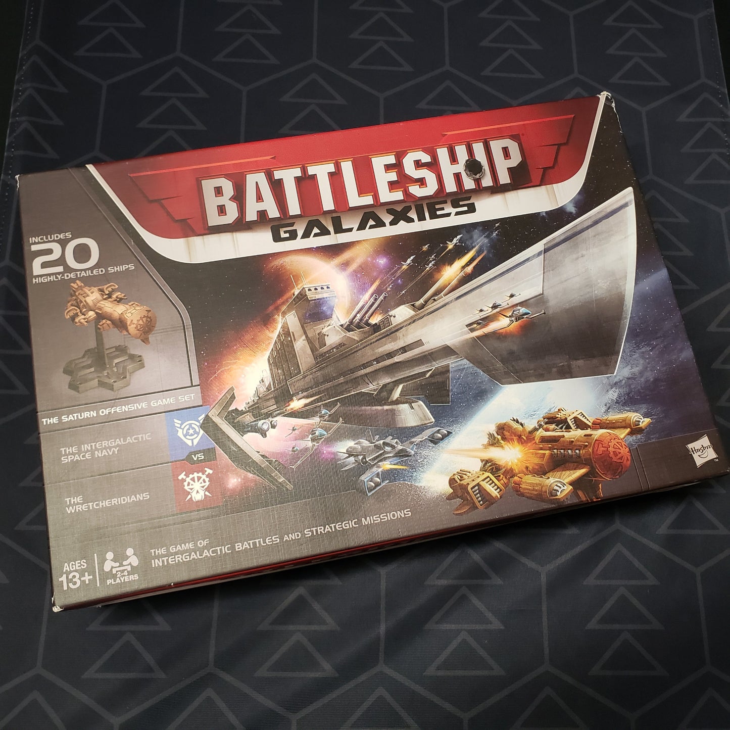 Image shows the front cover of the box of the Battleship Galaxies board game