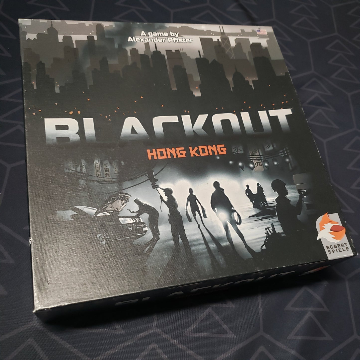 Image shows the front cover of the box for the Blackout: Hong Kong board game