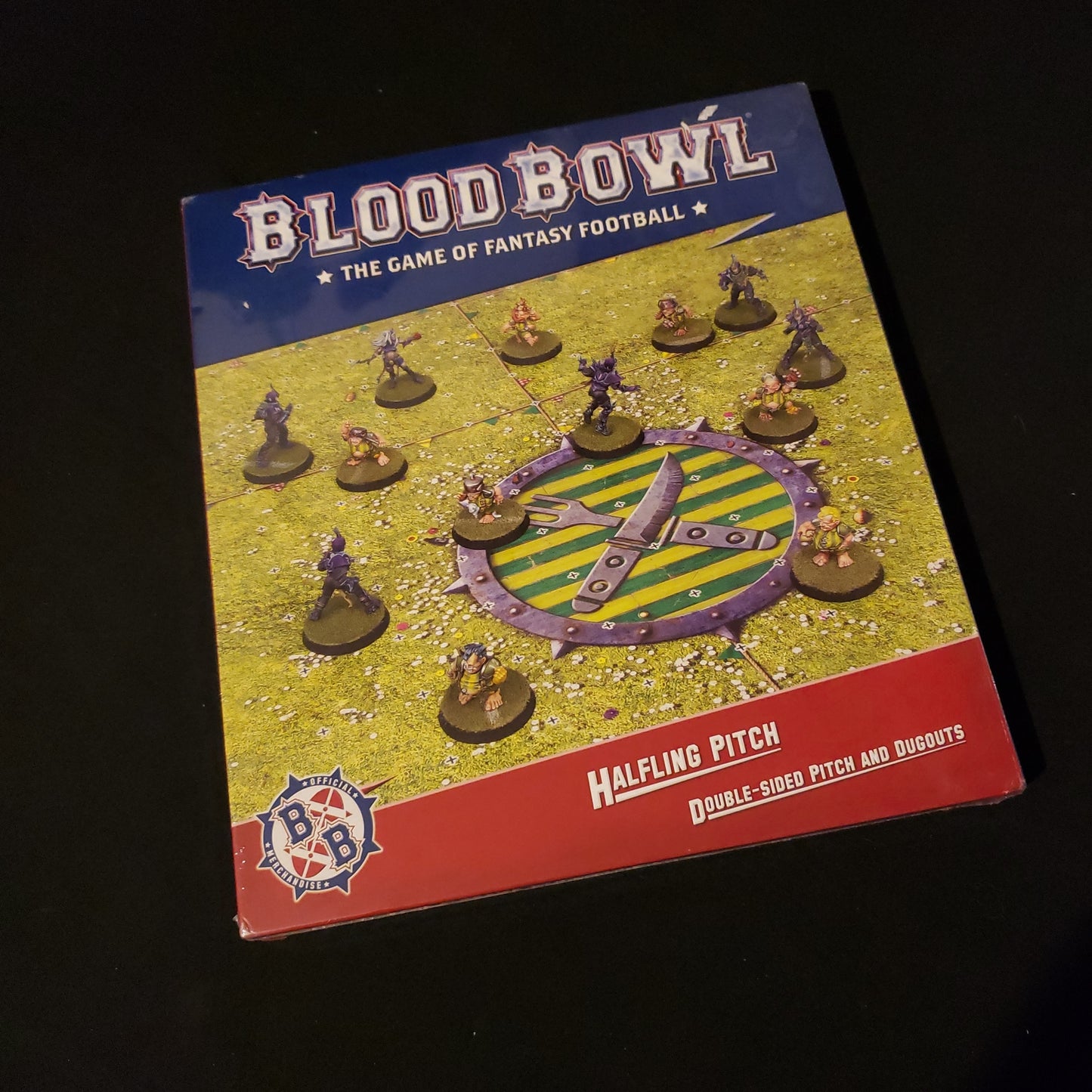 Image shows the front of the package for the Halfling Pitch & Dugout Pack for the Blood Bowl miniatures game