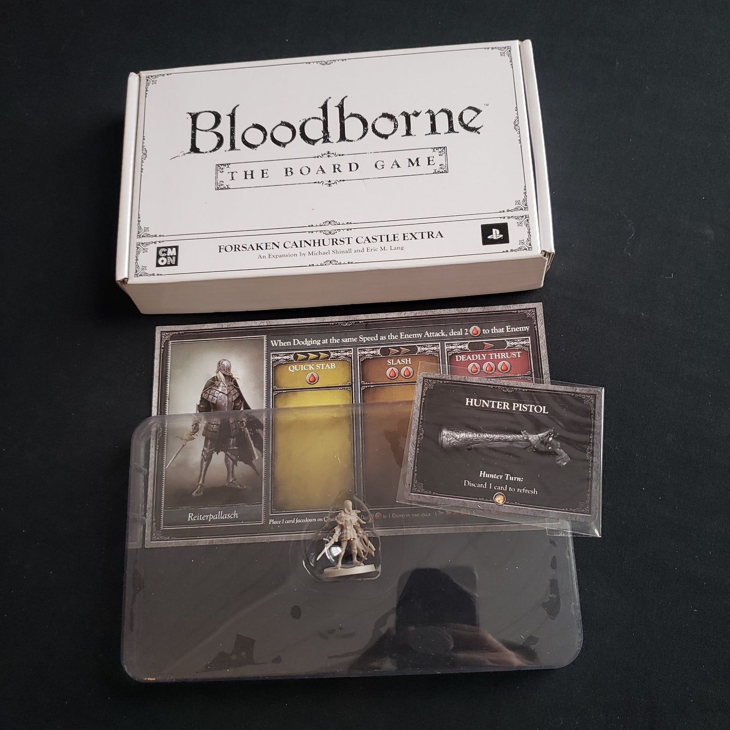 Image shows the components & box for the Forsaken Cainhurst Castle Extra expansion for Bloodborne: The Board Game