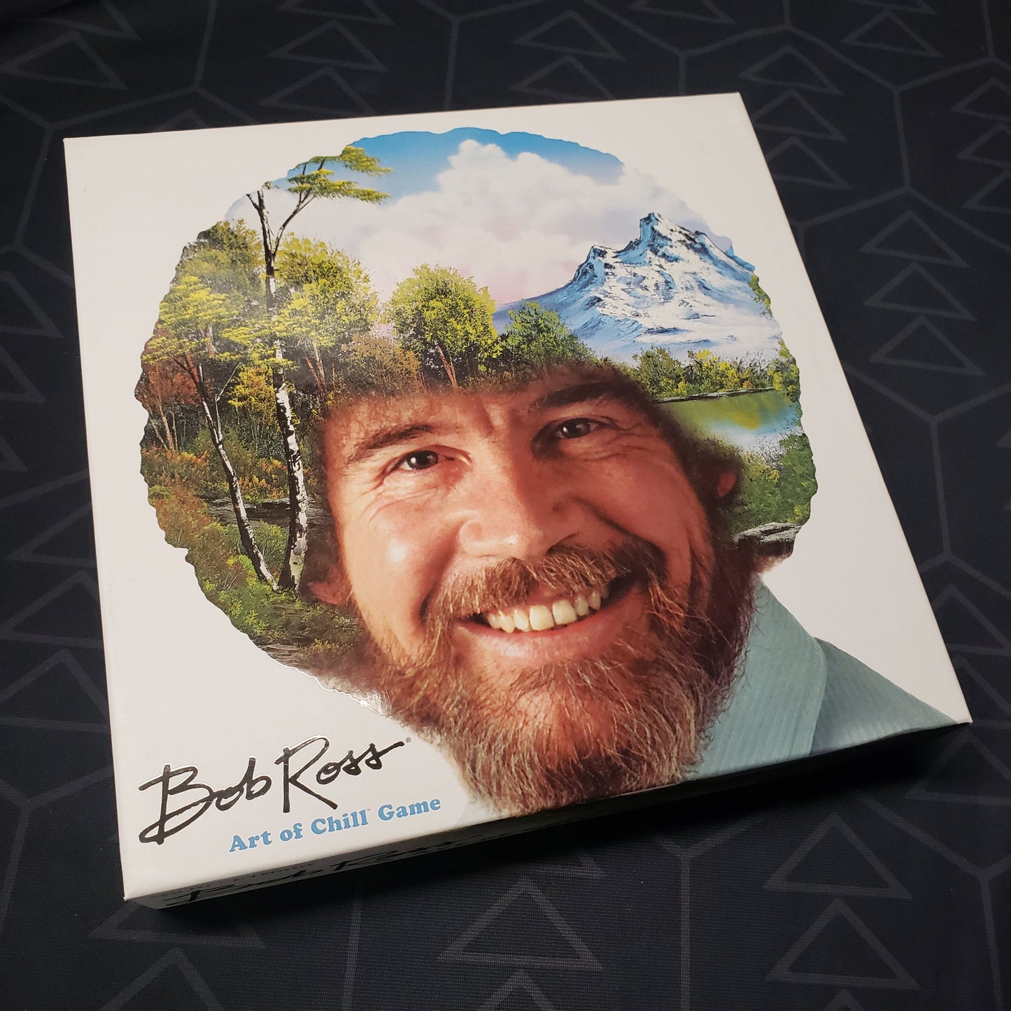 Image shows the front cover of the box for the Bob Ross: Art of Chill board game