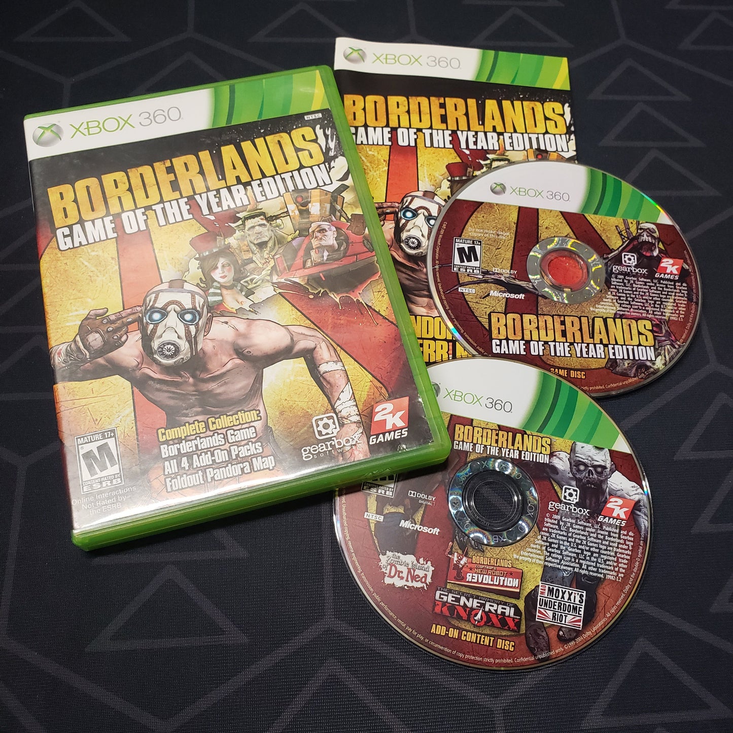 Image shows the case, manual and two discs for the video game Borderlands: Game of the Year Edition for Xbox 360