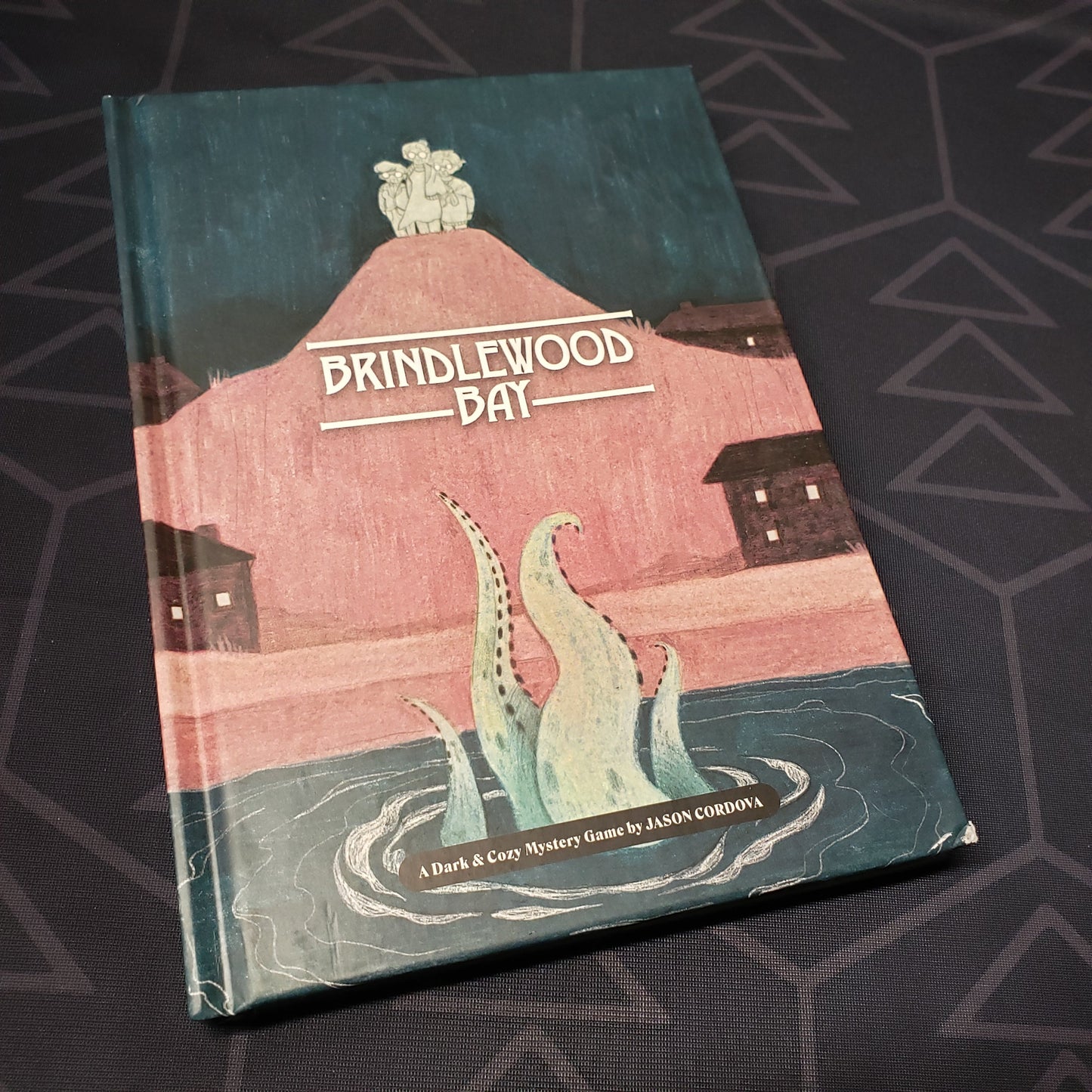 Image shows the front cover of the core rulebook for the Brindlewood Bay roleplaying game