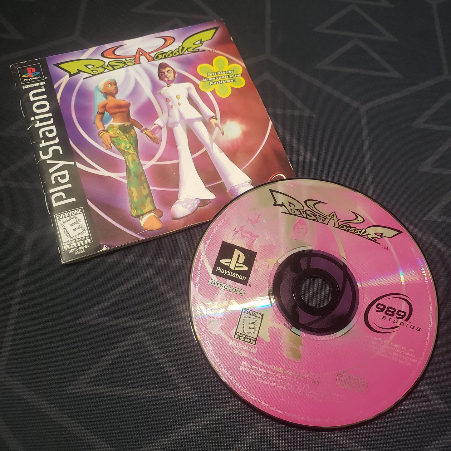 Image shows the label side of the game disc & the manual for the video game Bust A Groove for Playstation 1