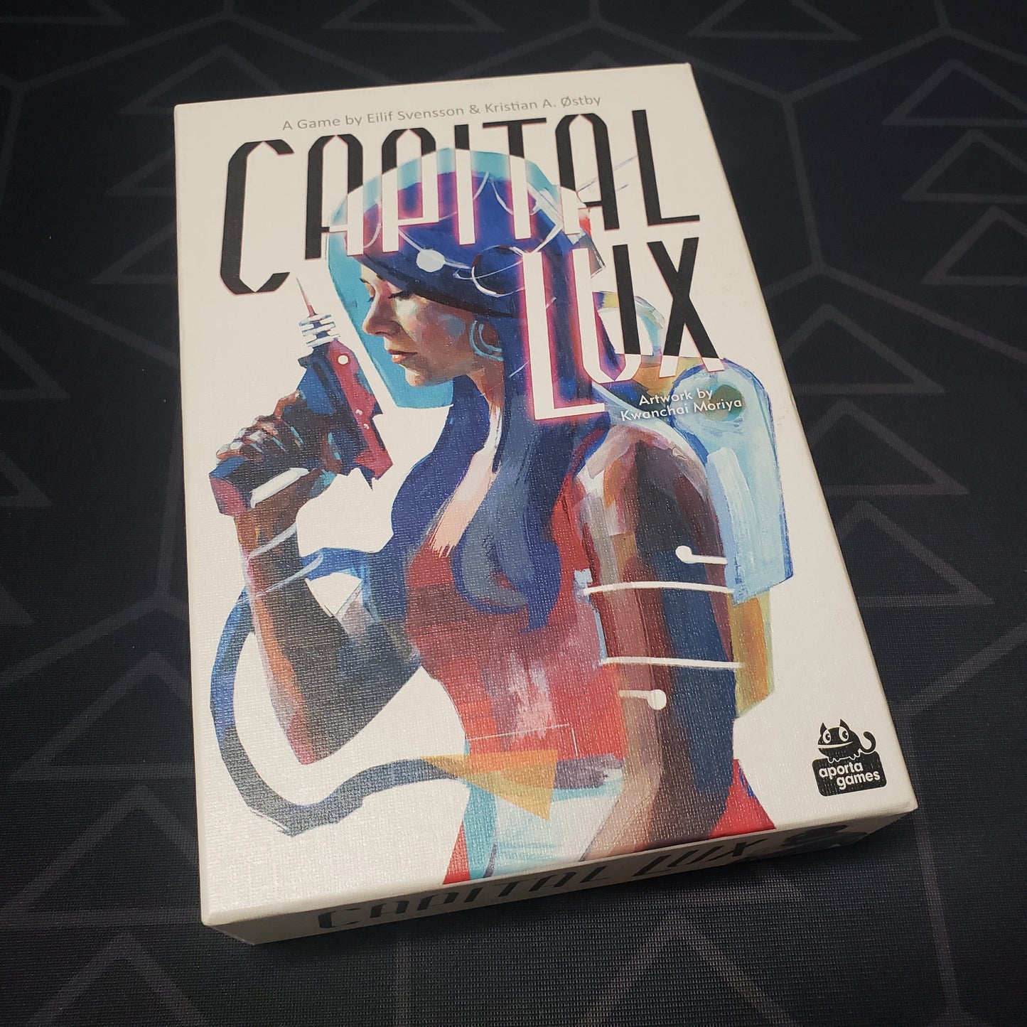 Image shows the front cover of the box for the Capital Lux card game