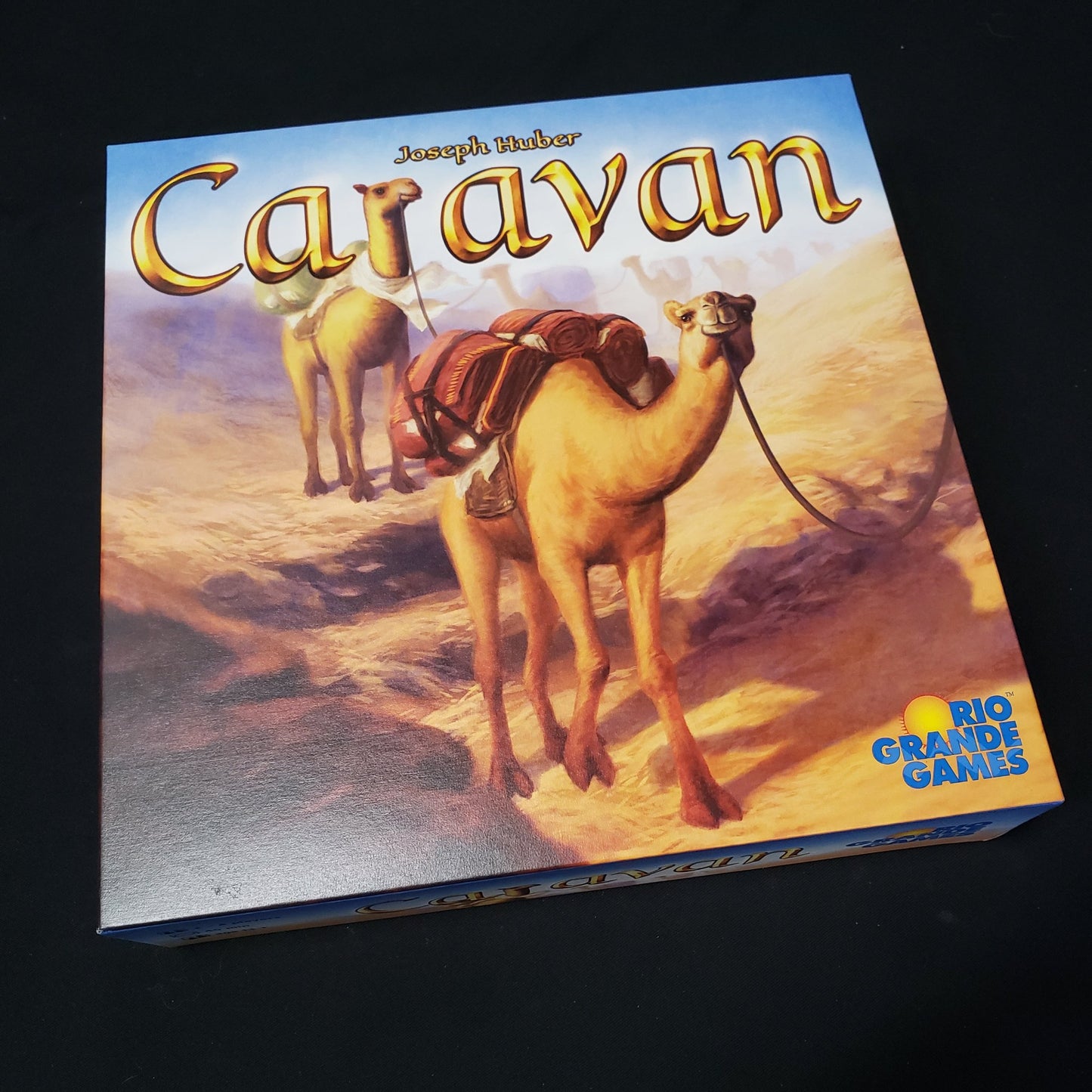 Image shows the front cover of the box of the Caravan board game