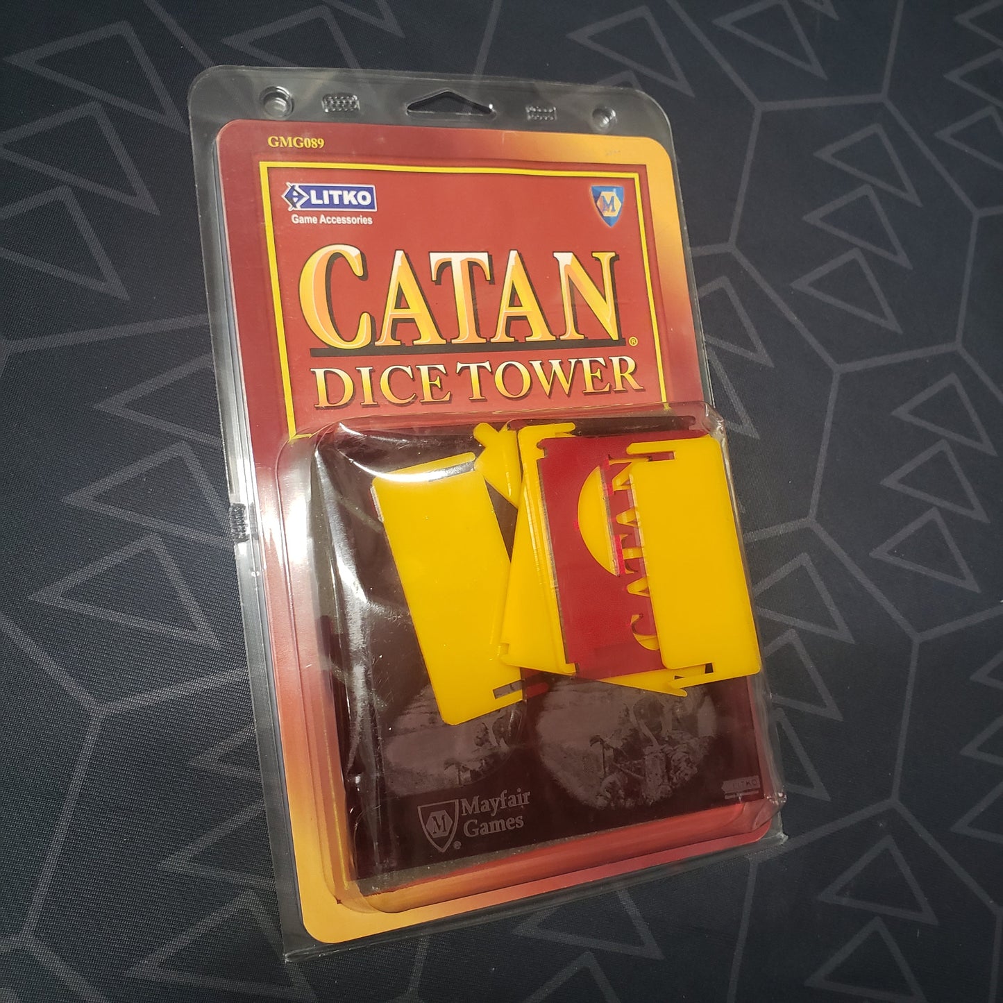 Image shows the front of the package for the official dice tower for the board game Catan