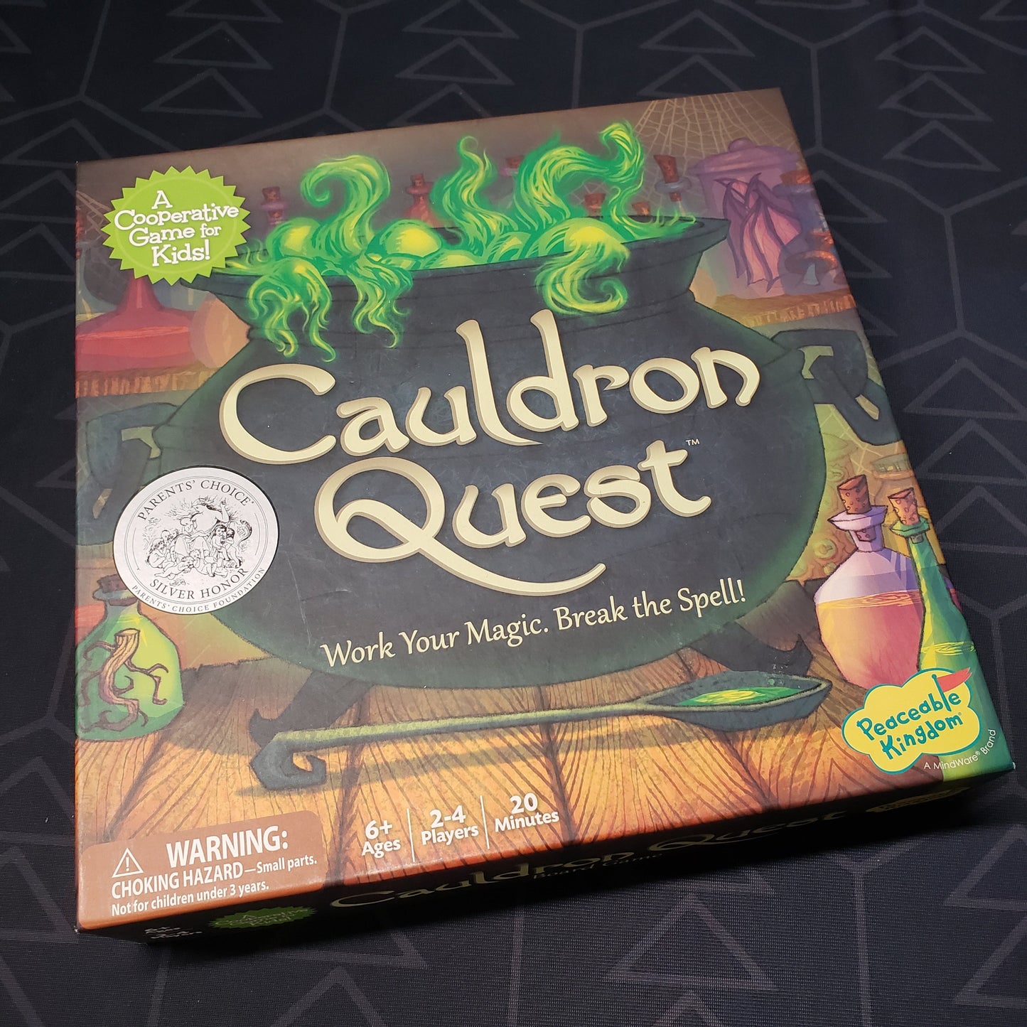 Image shows the front cover of the box of the Cauldron Quest board game