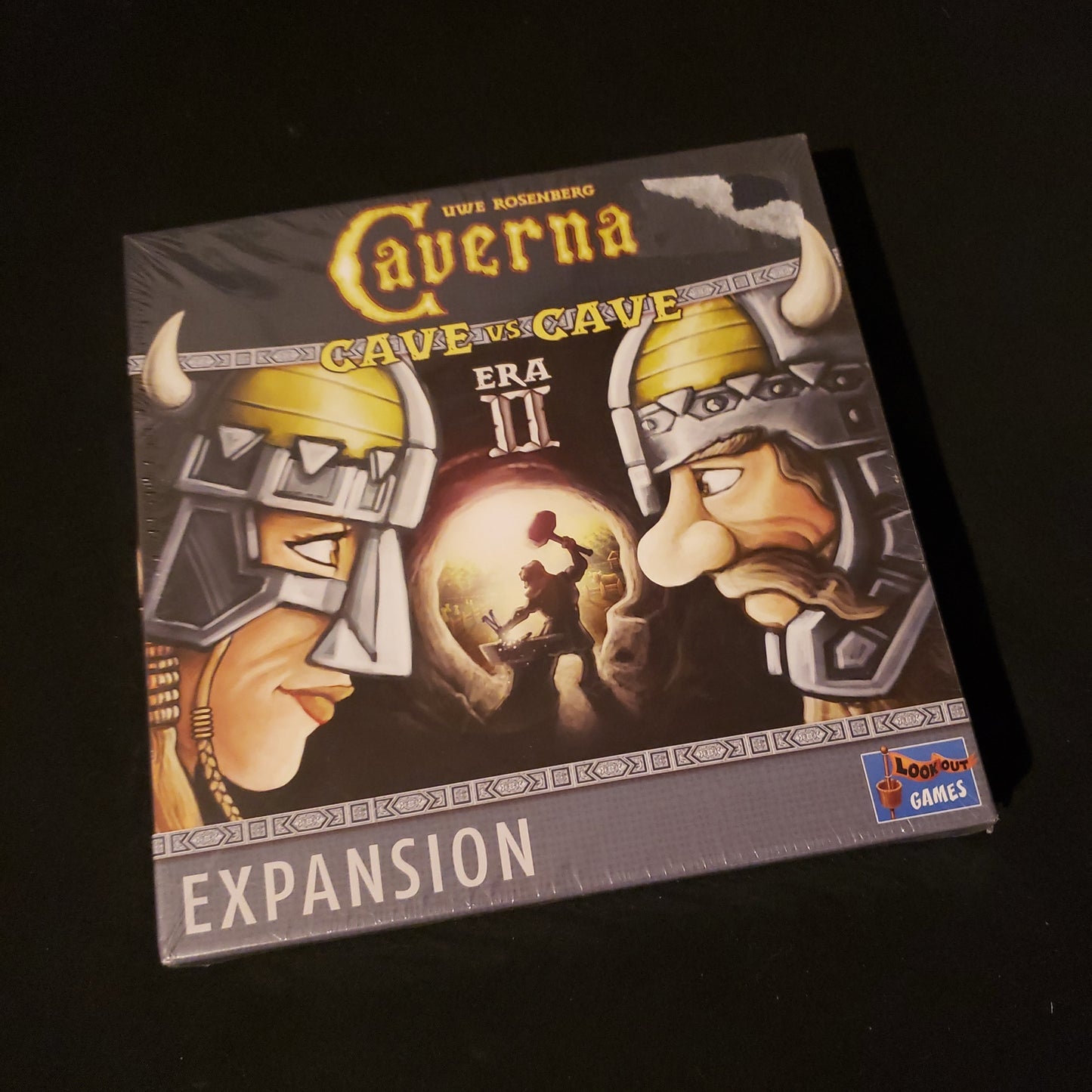 Image shows the front cover of the box of the Era II expansion for the board game Caverna: Cave vs Cave