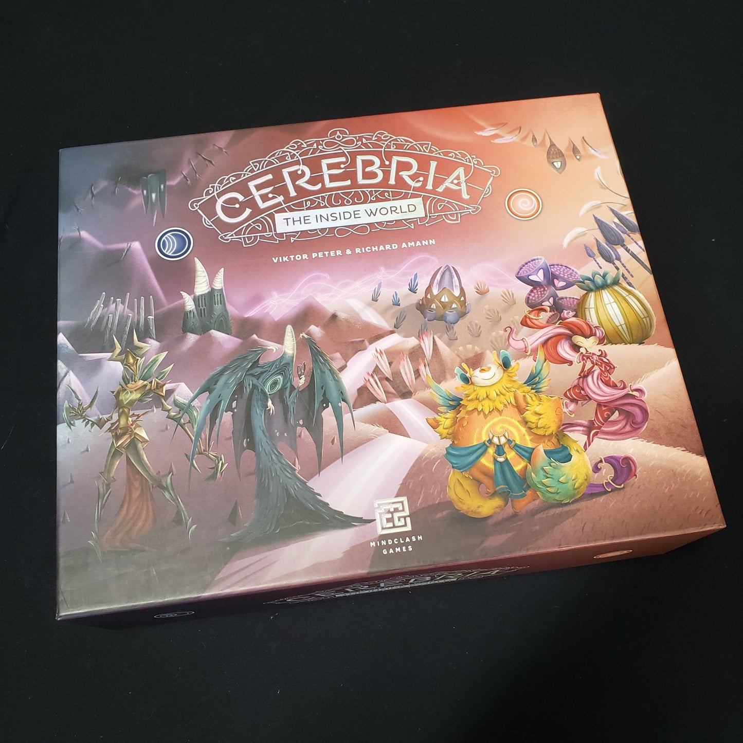 Image shows the front cover of the Origins Box of the board game Cerebria: The Inside World