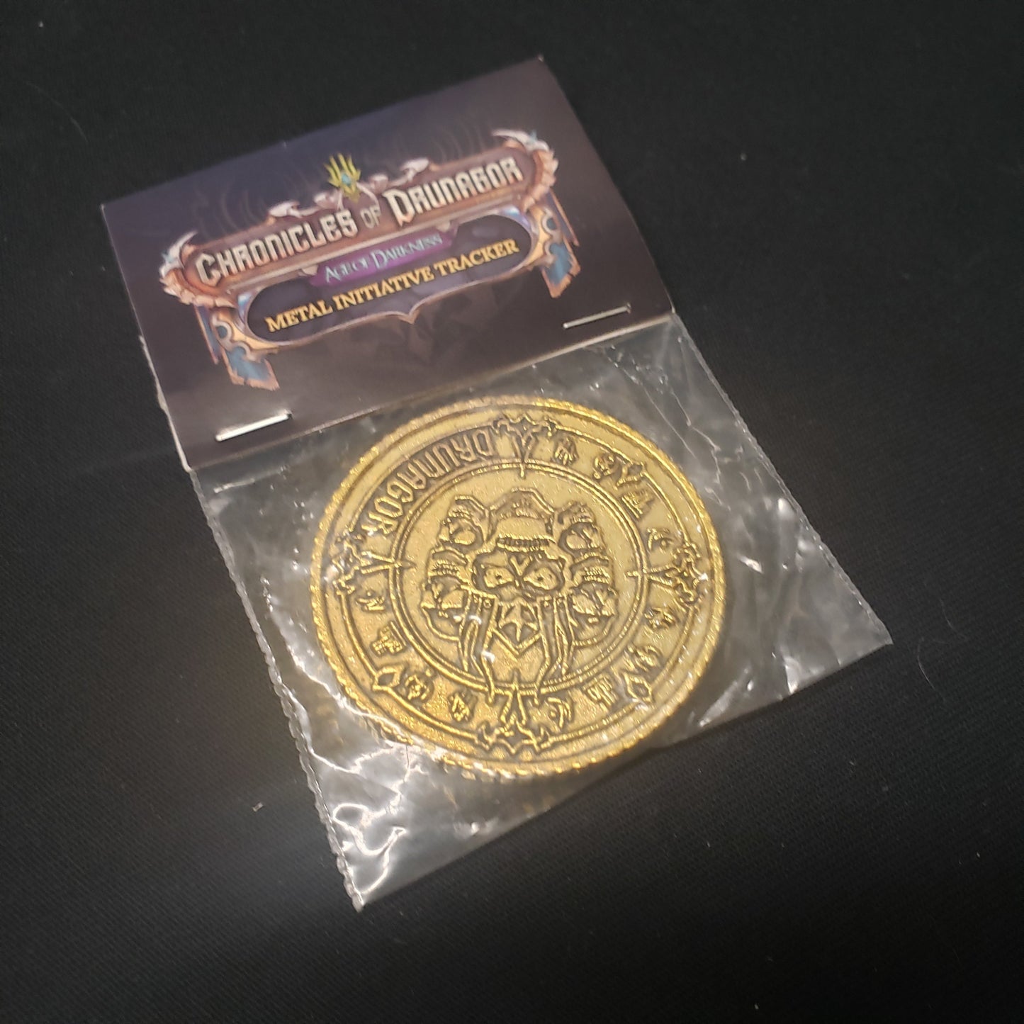 Image shows the front of the package of the metal Initiative Tracker for the board game Chronicles of Drunagor: Age of Darkness