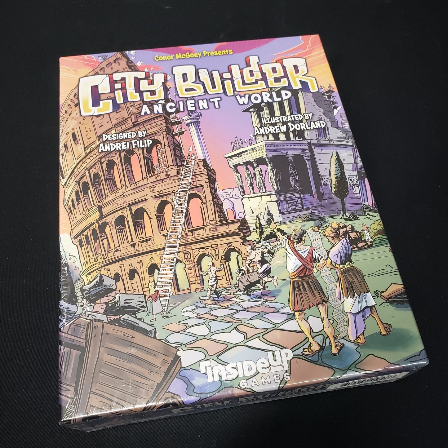 Image shows the front cover of the box of the City Builder: Ancient World board game