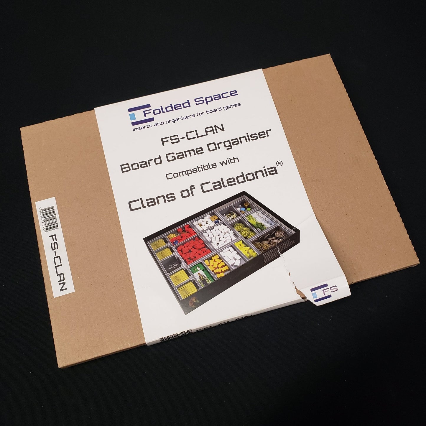 Image shows the front cover of the box of the Folded Space insert for the board game Clans of Caledonia