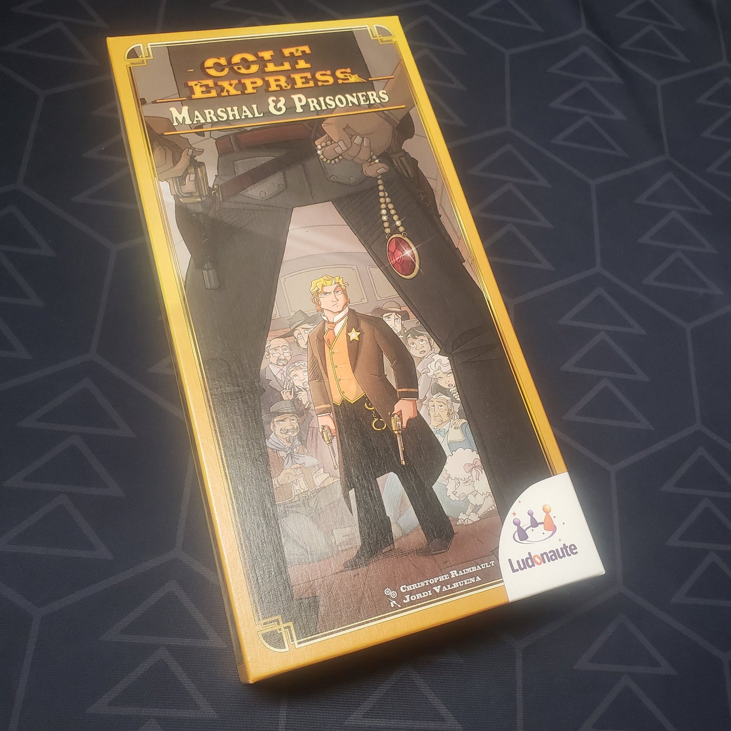 Image shows the front cover of the box of the Marshal & Prisoners expansion for the board game Colt Express