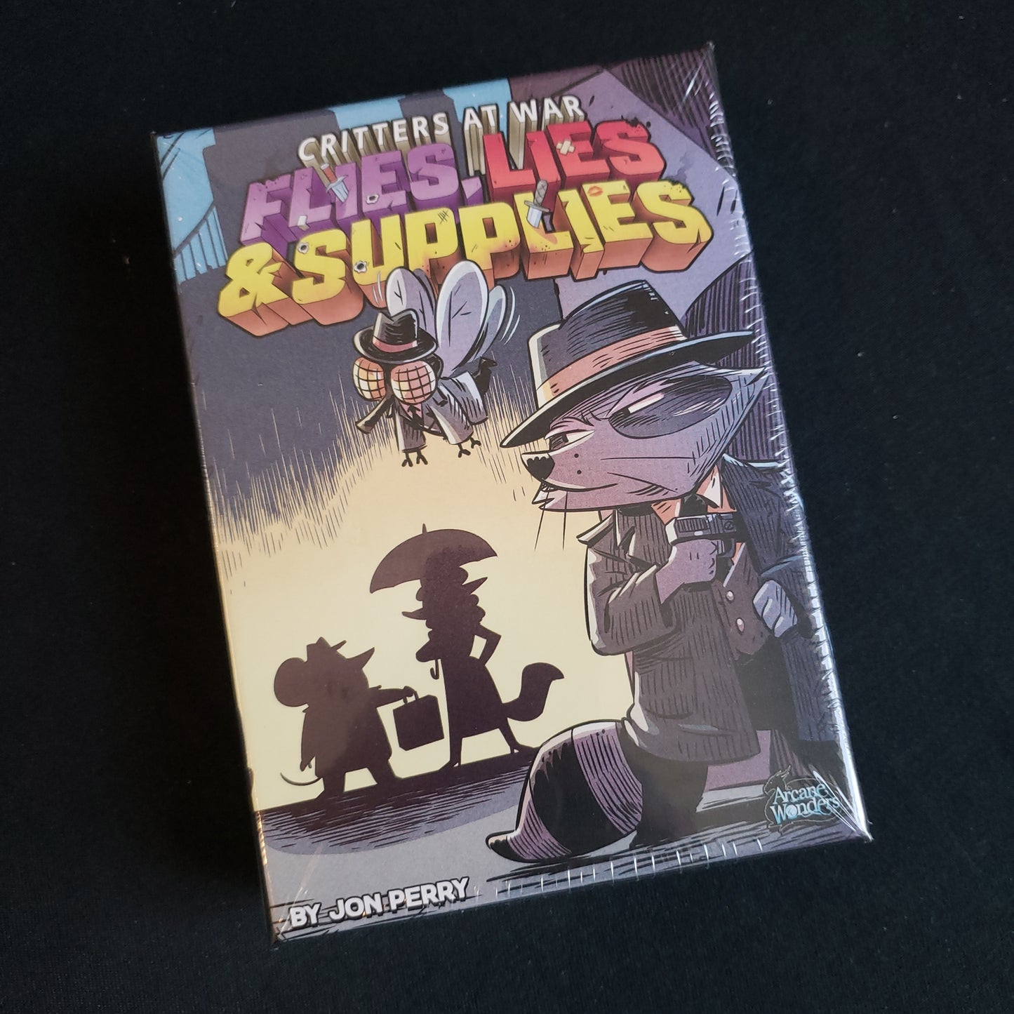 Image shows the front cover of the box of the Critters At War: Flies, Lies & Supplies card game