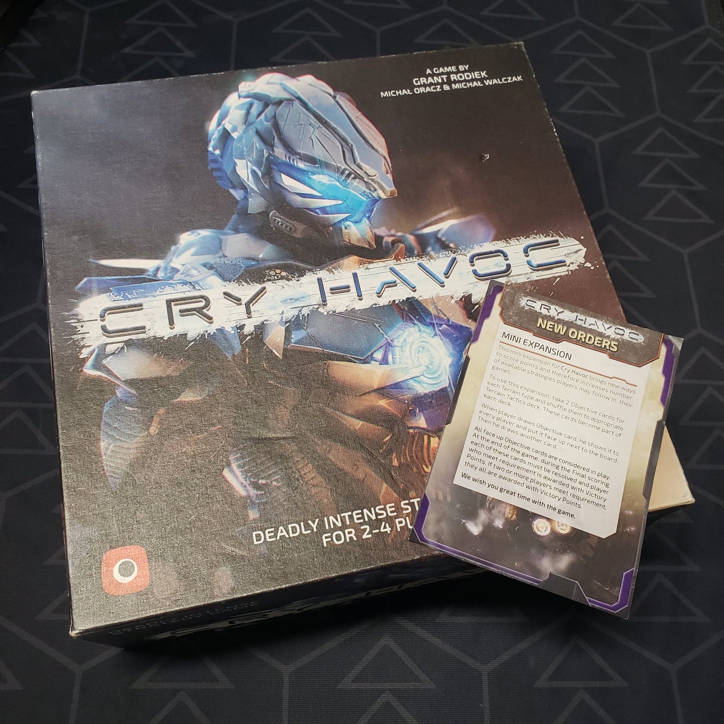 Image shows the front cover of the box of the Cry Havoc board game with the instructions for the New Orders mini expansion sitting on top of it
