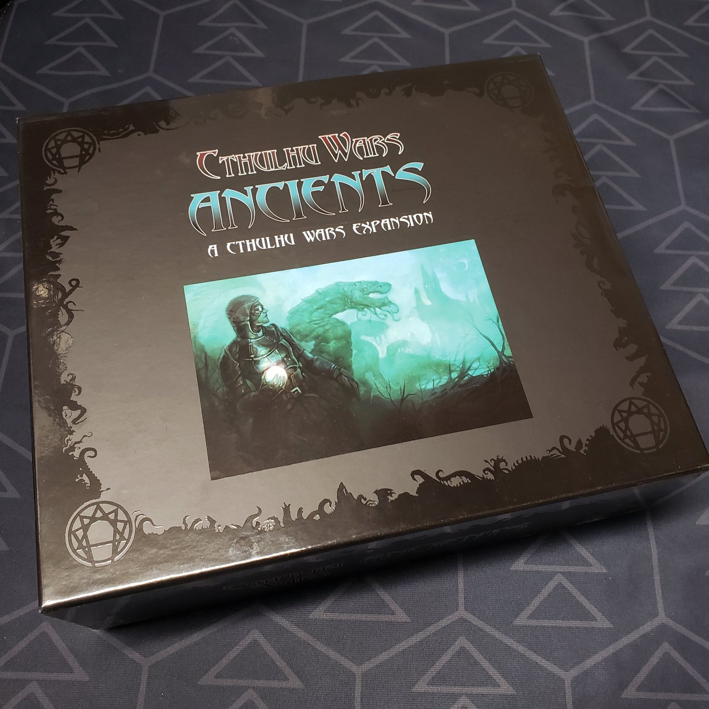 Image shows the front cover of the box of the Ancients expansion for the Cthulhu Wars board game