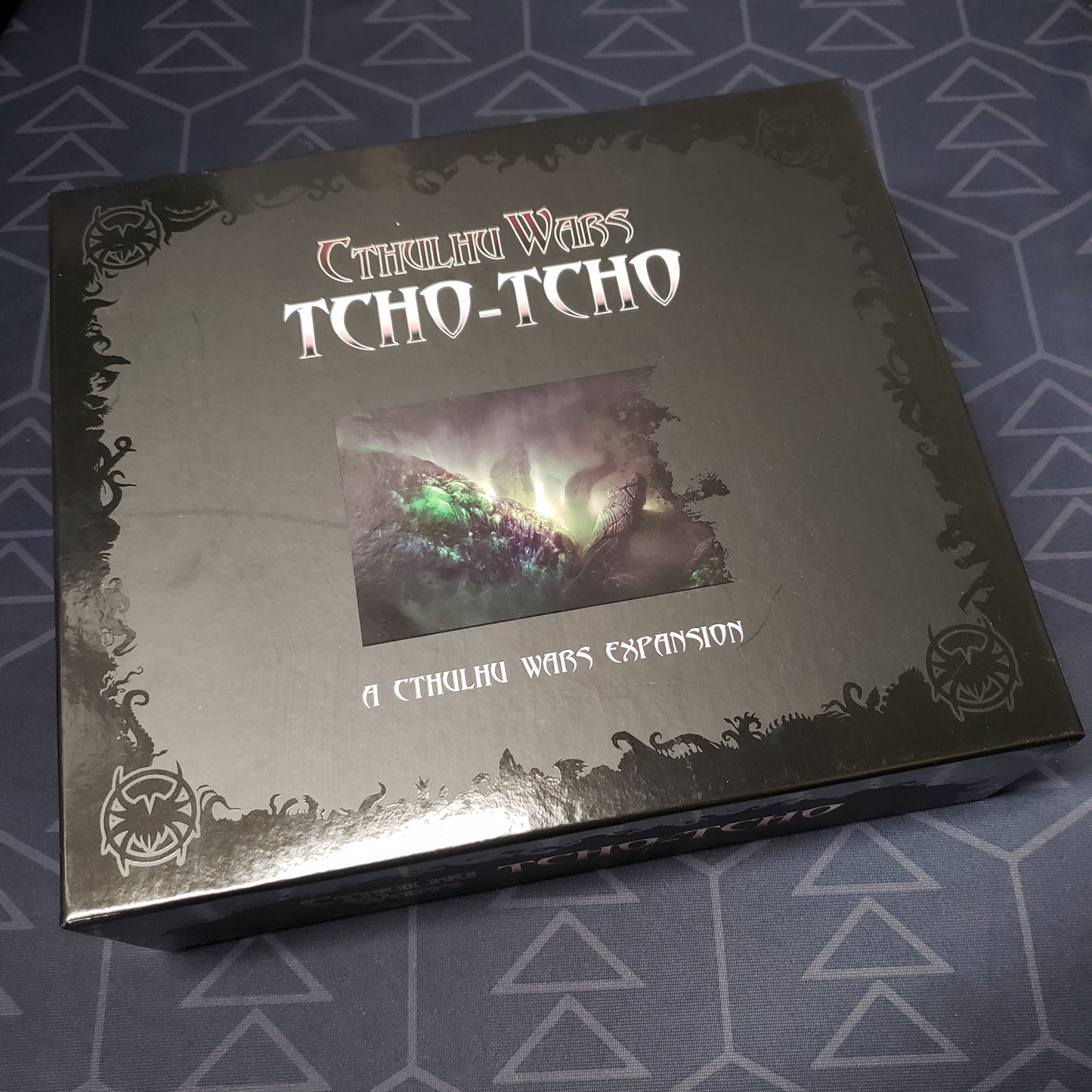 Image shows the front cover of the box of the Tcho-Tcho expansion for the board game Cthulhu Wars