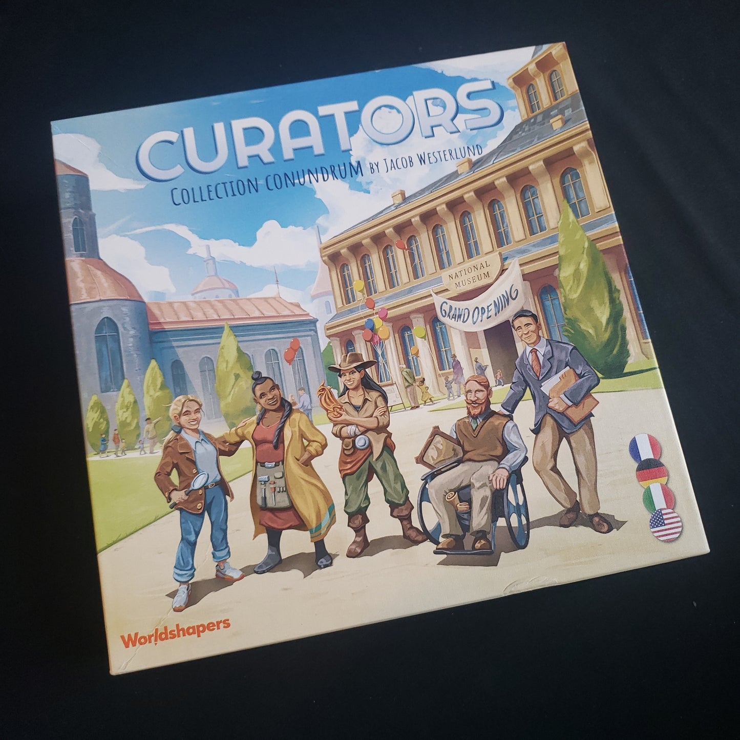 Image shows the front cover of the box of the Curators board game