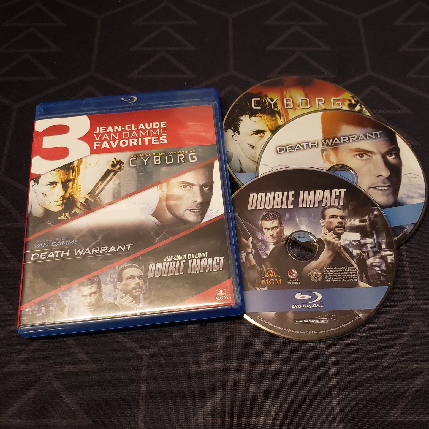 Image shows the case & three discs for the movie set of Cyborg, Death Warrant & Double Impact on Blu-Ray