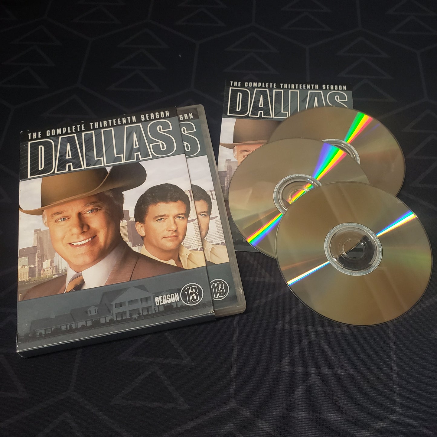 Image shows the outer box, case, booklet & three discs for Dallas: Season 13 on DVD