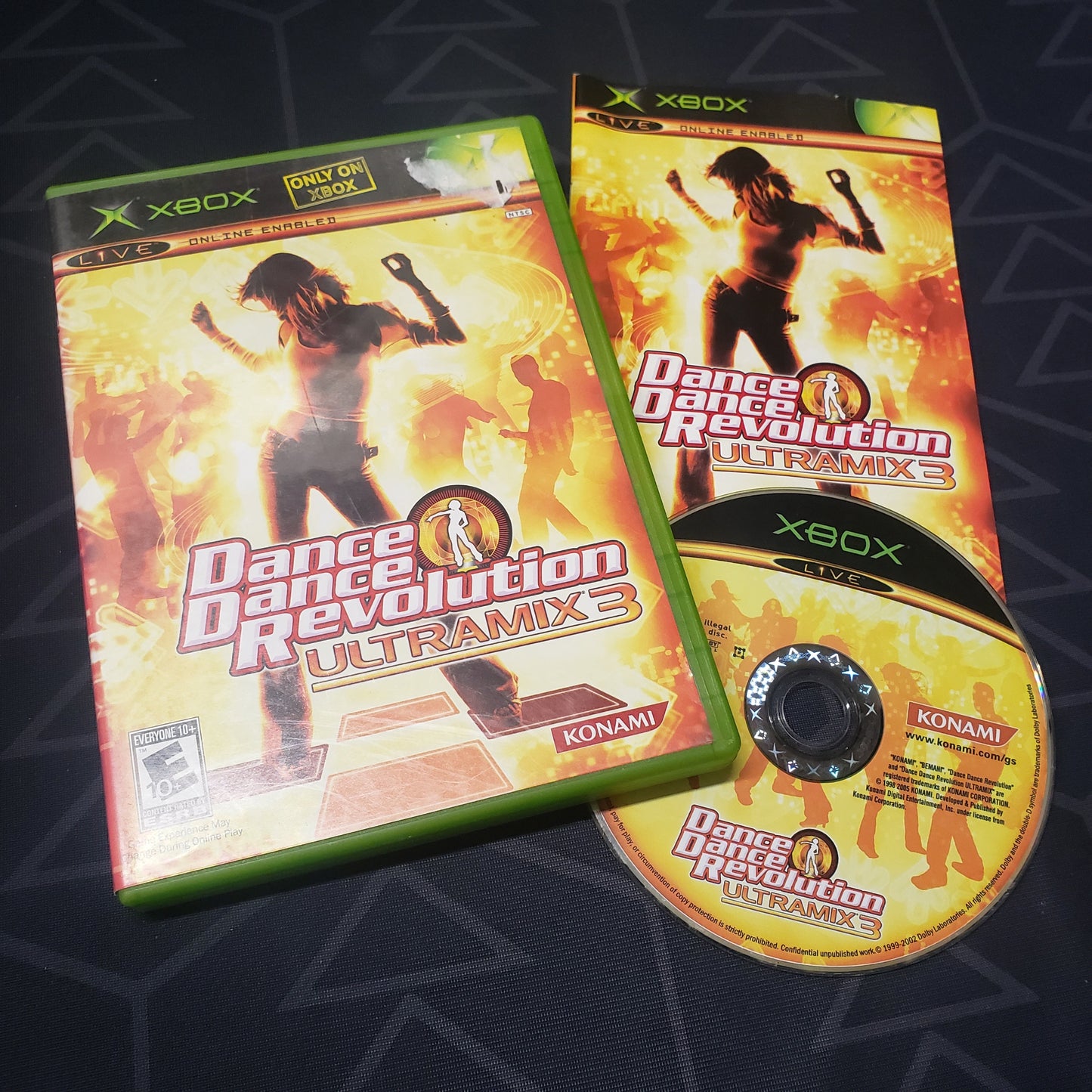 Image shows the case, manual and disc for the video game Dance Dance Revolution: Ultramix 3 for the original Xbox