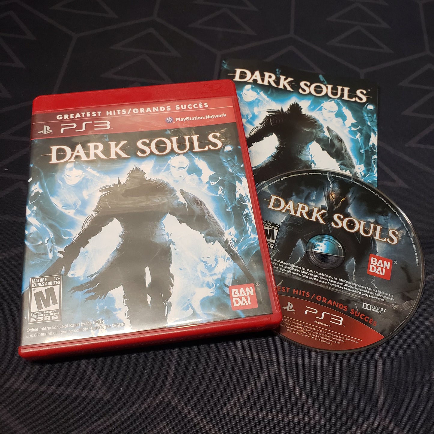 Image shows the case, manual and disc for the video game Dark Souls for Playstation 3