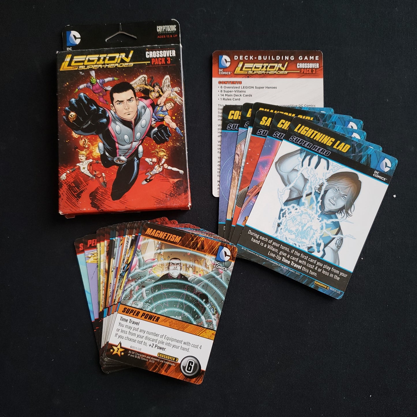 Image shows the front cover of the box of the Legion of Super-Heroes Crossover Pack expansion for the DC Comics Deckbuilding card game, along with the cards fanned out next to it