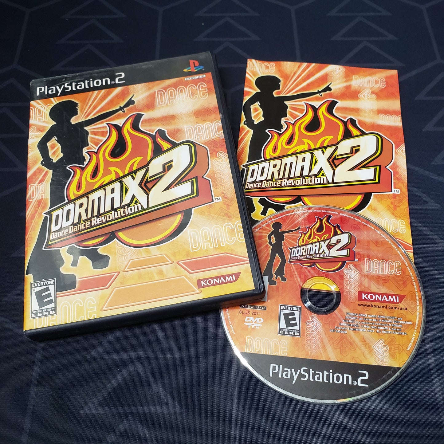Image shows the case, manual & disc for the video game DDRMX2: Dance Dance Revolution for Playstation 2