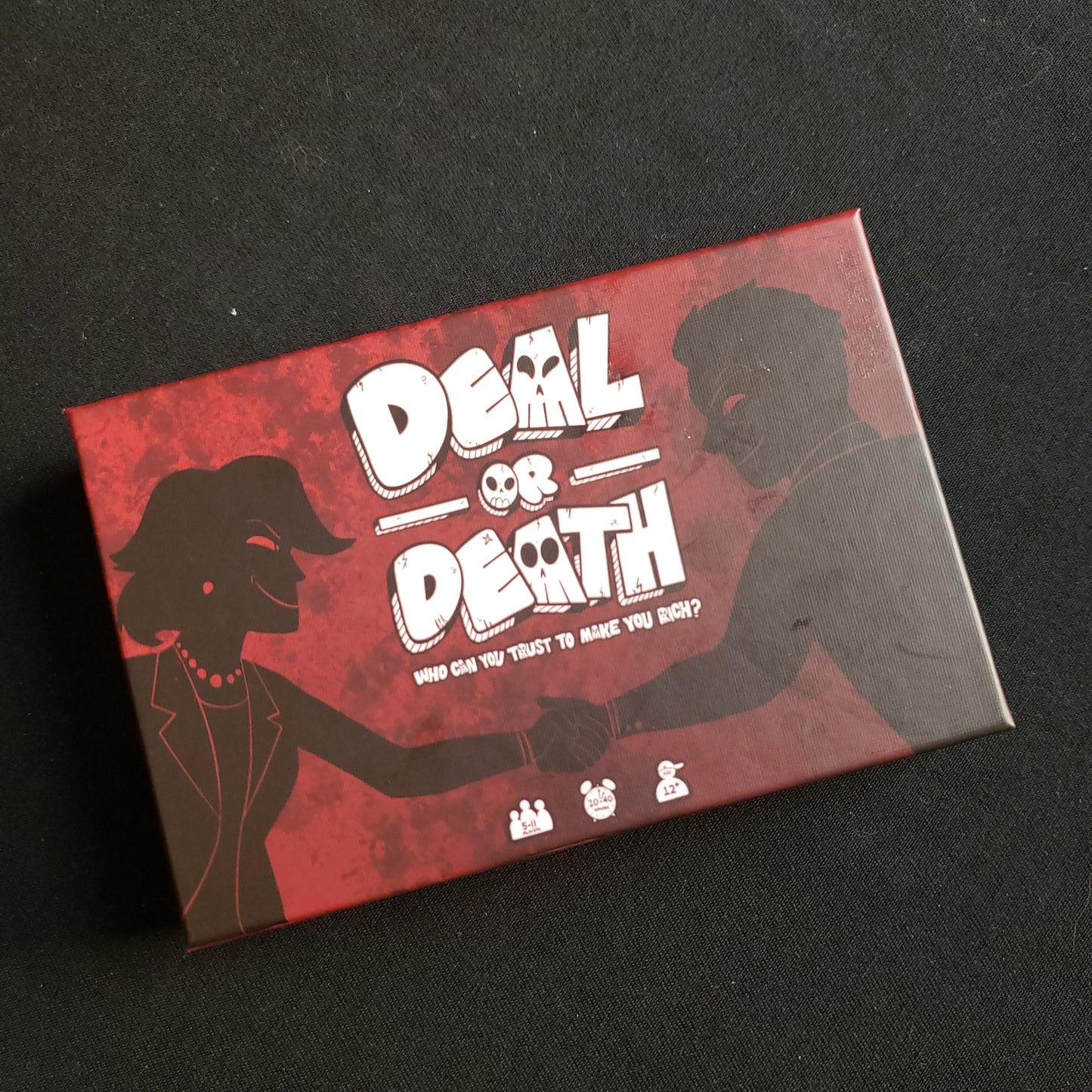 Image shows the front cover of the box of the Deal or Death card game
