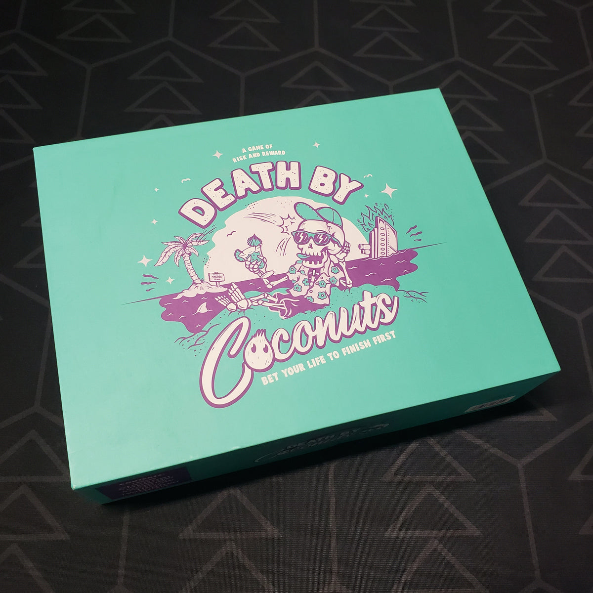 Image shows the front cover of the box for the Death by Coconuts board game