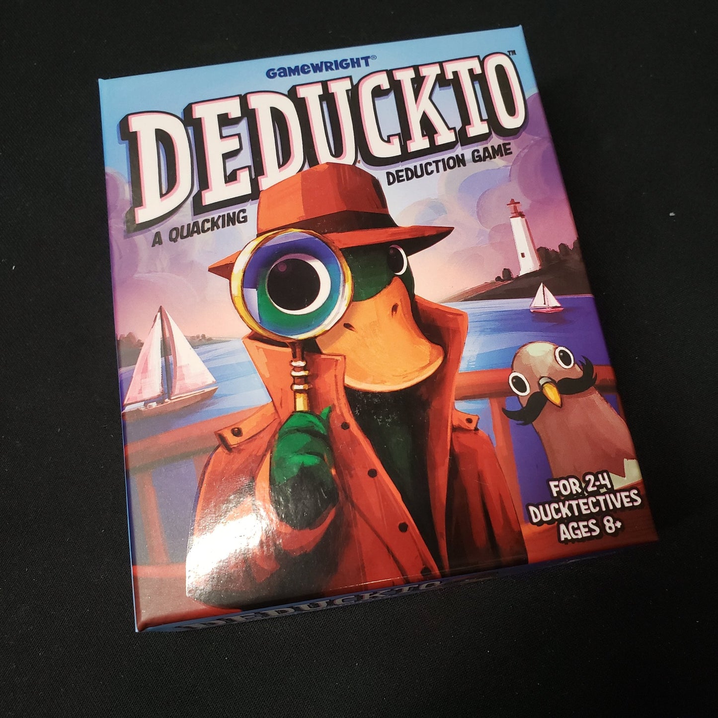 Image shows the front cover of the box of the Deduckto card game