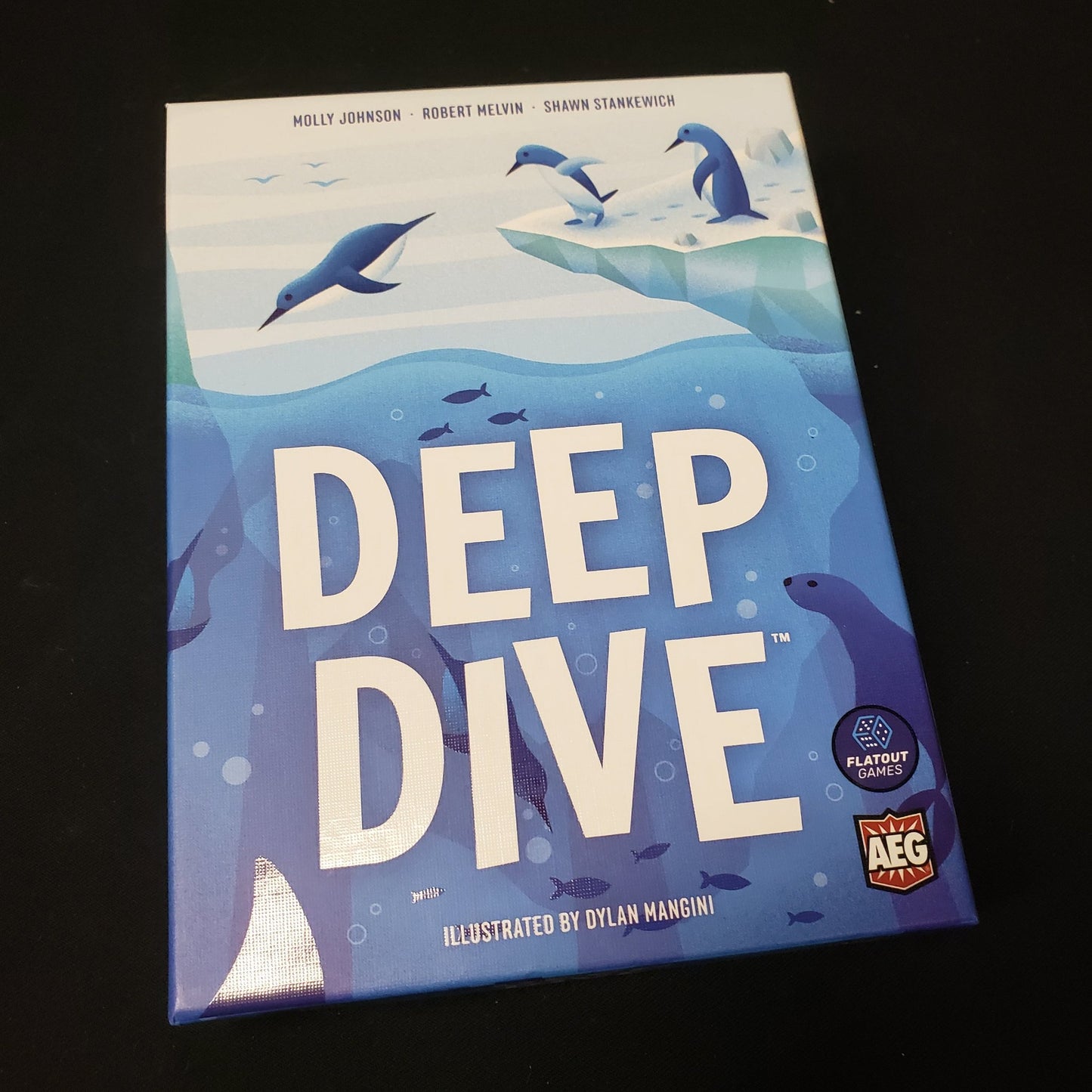 Image shows the front cover of the box of the Deep Dive board game