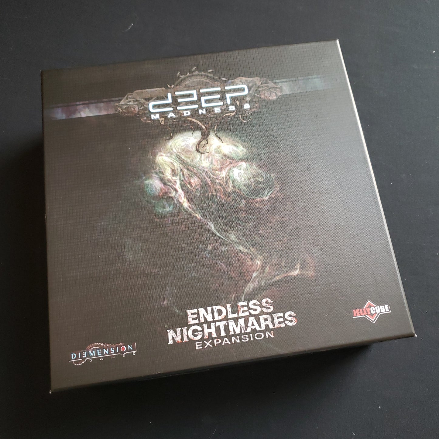 Image shows the front cover of the box of the Endless Nightmares expansion for the Deep Madness board game