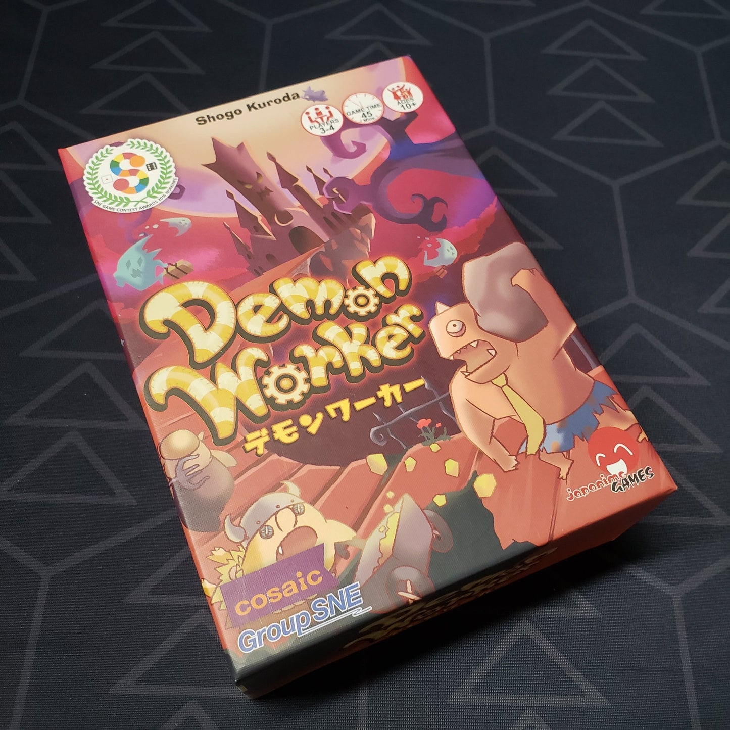 Image shows the front cover of the box of the Demon Worker board game